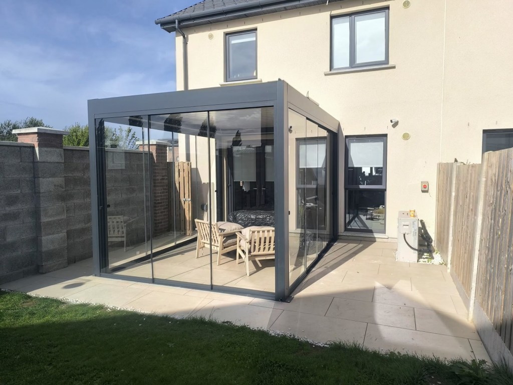 Aluminium pergola with sliding glass walls on a patio