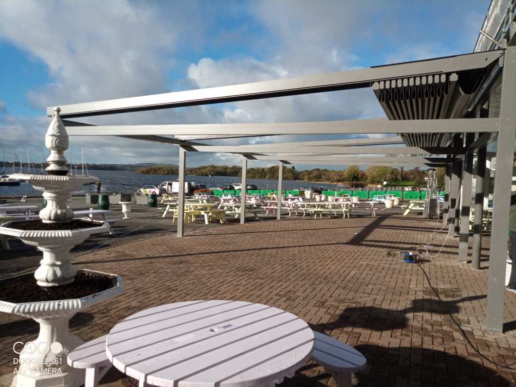 Commercial pergola shading outdoor seating at a waterside venue