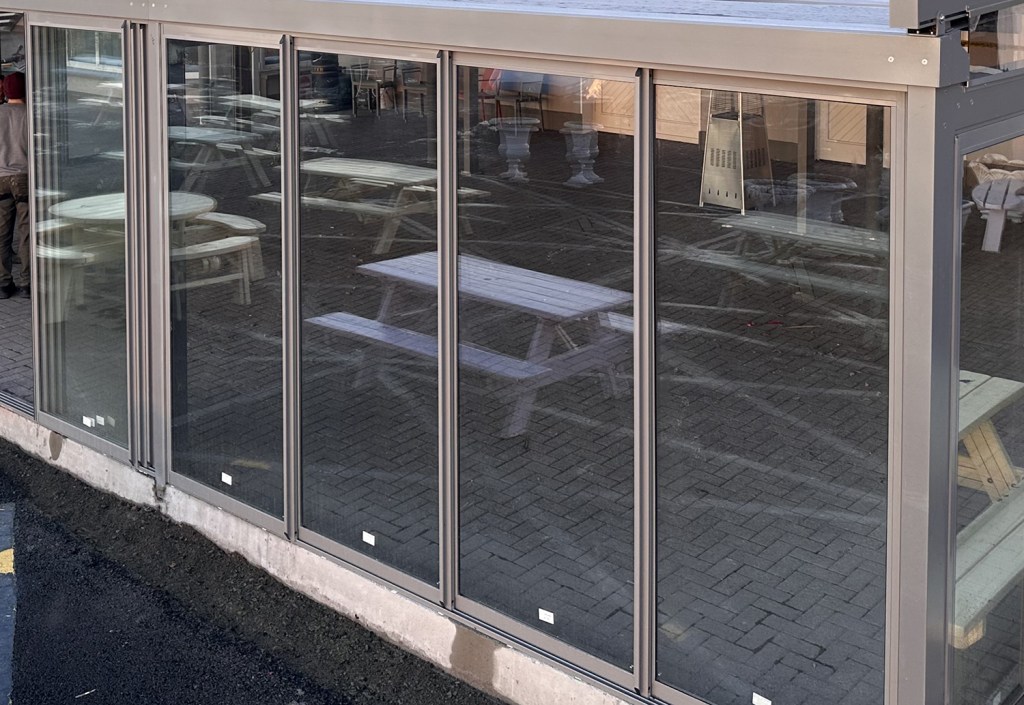 Glass sliding walls enclosing a commercial outdoor area
