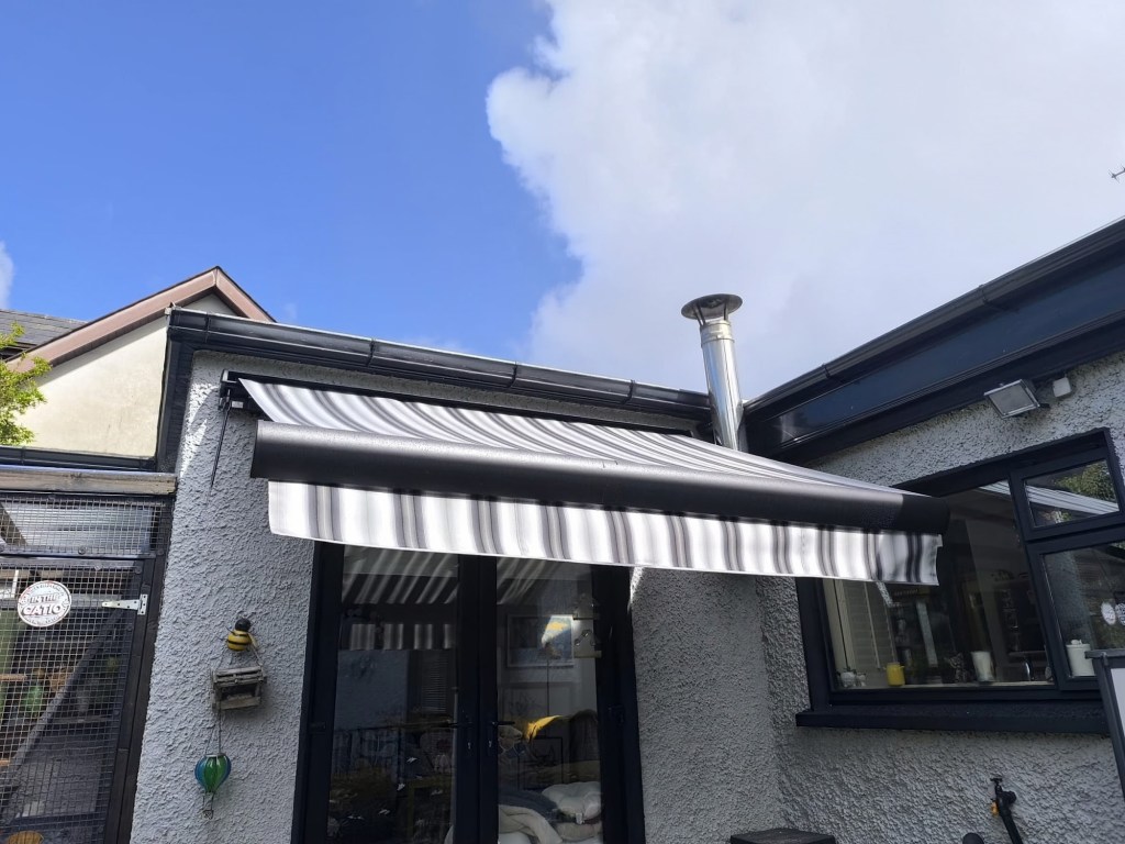 Grey and white striped retractable awning on an Irish house