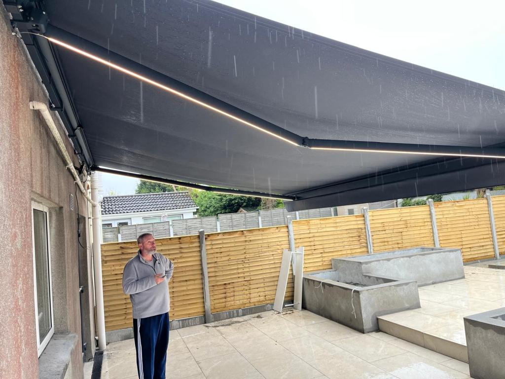 Large retractable patio awning fully extended over a garden terrace
