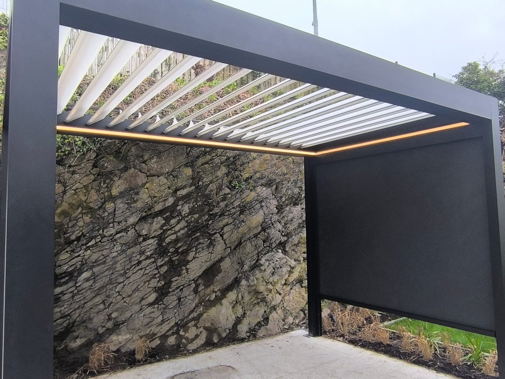 Louvred pergola roof with LED lighting against a stone wall