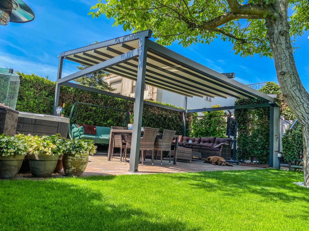 Retractable pergola with fabric roof in a landscaped garden