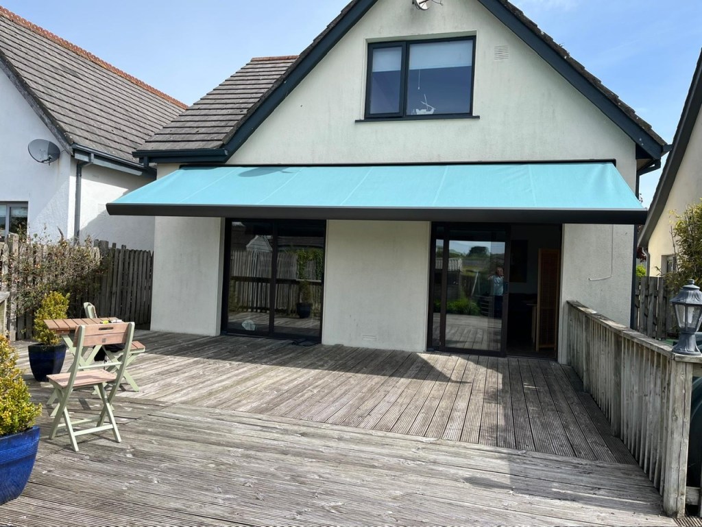 Turquoise retractable awning over a timber deck