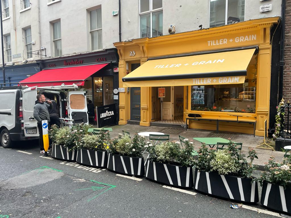 Yellow and red commercial awnings over shops and a café